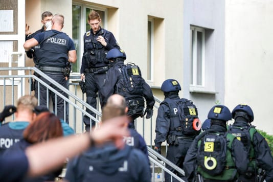 Officers of the federal police go into an apartment building as part of a search in Weissenfles, Germany, Wednesday, Sept. 23, 2020. The federal police searched more than 60 residential and business premises in five states on Wednesday on suspicion of illegal smuggling of workers for the meat industry. Approximately 800 officers were involved in the raid - mainly in Saxony-Anhalt and Lower Saxony, according to a spokesperson for the Central German Federal Police. The nationwide raid on the illegal smuggling of workers for the meat industry will focus on Weissenfels. (Jan Woitas/dpa via AP) Officers of the federal police go into an apartment building as part of a search in Weissenfles, Germany, Wednesday, Sept. 23, 2020. The federal police searched more than 60 residential and business premises in five states on Wednesday on suspicion of illegal smuggling of workers for the meat industry. Approximately 800 officers were involved in the raid - mainly in Saxony-Anhalt and Lower Saxony, according to a spokesperson for the Central German Federal Police. The nationwide raid on the illegal smuggling of workers for the meat industry will focus on Weissenfels. (Jan Woitas/dpa via AP)