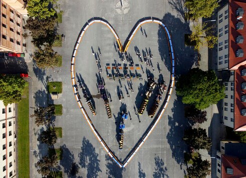 An oversized heart was formed from beer benches on the former parade ground of the Luitpold Barracks, in Munich, Germany, Saturday, Sept.19, 2020. In the middle are brewery carriages and guests of the organizer. The event was organized by the Munich Breweries Association because the Oktoberfest 2020 was cancelled due to the Corona pandemic. (Peter Kneffel//dpa via AP)