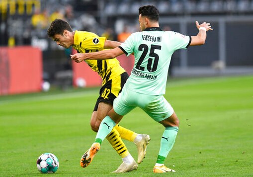 Dortmund's Giovanni Reyna, left, and Monchengladbach's Ramy Bensebaini fight for the ball during the Bundesliga soccer match between Borussia Dortmund and Borussia Monchengladbach at Signal Iduna Park, Dortmund, Germany, Saturday Sept. 19, 2020. (Bernd Thissen/Pool via AP)