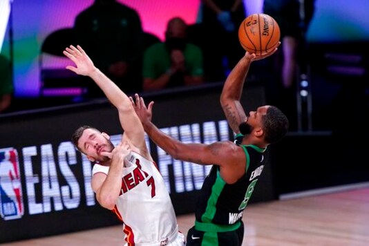 Miami Heat guard Goran Dragic (7) is knocked backwards on a shot attempt by Boston Celtics guard Brad Wanamaker (9) during the first half of an NBA conference final playoff basketball game, Thursday, Sept. 17, 2020, in Lake Buena Vista, Fla. (AP Photo/Mark J. Terrill)
