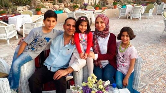 This undated 2018 photo shows Dr. Mohammed Ayesh and his family in Gaza. Ayesh is among several Gazans who are unable to return to the territory because of a dispute between Israel and the Palestinian Authority. The PA stopped coordinating travel permits with Israel when it cut off all contacts in May 2020 to protest Israel's plans to annex up to 30% of the occupied West Bank. (Ayesh family via AP) This undated 2018 photo shows Dr. Mohammed Ayesh and his family in Gaza. Ayesh is among several Gazans who are unable to return to the territory because of a dispute between Israel and the Palestinian Authority. The PA stopped coordinating travel permits with Israel when it cut off all contacts in May 2020 to protest Israel's plans to annex up to 30% of the occupied West Bank. (Ayesh family via AP)
