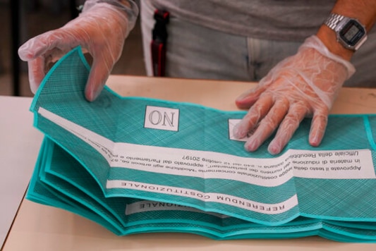 Scrutineers count ballots after the closing of a polling station, in Rome, Monday, Sept. 21, 2020. On Sunday and Monday Italians  voted nationwide in a referendum to confirm a historical change to the country's constitution to drastically reduce the number of Members of Parliament from 945 to 600. Eighteen million of Italian citizens will also vote on Sunday and Monday to renew local governors in seven regions, along with mayors in approximately 1,000 cities. (AP Photo/Andrew Medichini)