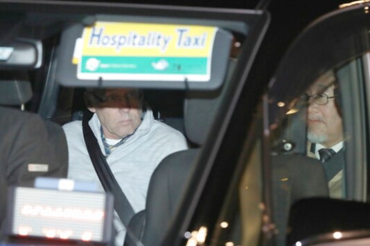 FILE - In this Tuesday, Dec. 25, 2018, file photo, a car carrying Nissan Motor Co.'s executive Greg Kelly, left, leaves Tokyo's Detention Center in Tokyo. The criminal trial against Japanese automaker Nissan and its former executive Greg Kelly will open in Tokyo District Court on Sept. 15. Its the latest chapter in the unfolding scandal of Carlos Ghosn, a superstar at Nissan Motor Co. until he and Kelly were arrested in late 2018. (AP Photo/Eugene Hoshiko, File)