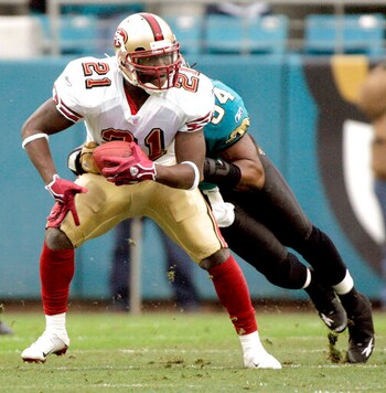 FILE - In this Dec. 18, 2005, file photo, San Francisco 49ers running back Frank Gore, left, is tackled by Jacksonville Jaguars defender Mike Peterson, right, during the second quarter of an NFL football game in Jacksonville, Fla. Gore took his first NFL snaps as a pro with the 49ers in 2005 in what seems like a lifetime ago for the NFLs third-leading rusher. It all comes full circle for the 37-year-old Gore on Sunday, Sept. 20, 2020, when his New York Jets host the team with which he began his career 16 years ago. (AP Photo/Phil Coale, File)