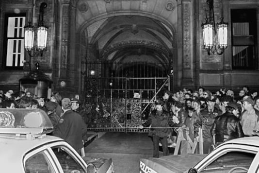 FILE - In this Dec. 9, 1980, file photo, a crowd gathers outside the Dakota apartment building after John Lennon, who lived there, was shot hours earlier in front of the building when returning home on the evening of Dec. 8. Mark David Chapman, who shot and killed Lennon, said he was seeking glory and deserved the death penalty for the FILE - In this Dec. 9, 1980, file photo, a crowd gathers outside the Dakota apartment building after John Lennon, who lived there, was shot hours earlier in front of the building when returning home on the evening of Dec. 8. Mark David Chapman, who shot and killed Lennon, said he was seeking glory and deserved the death penalty for the