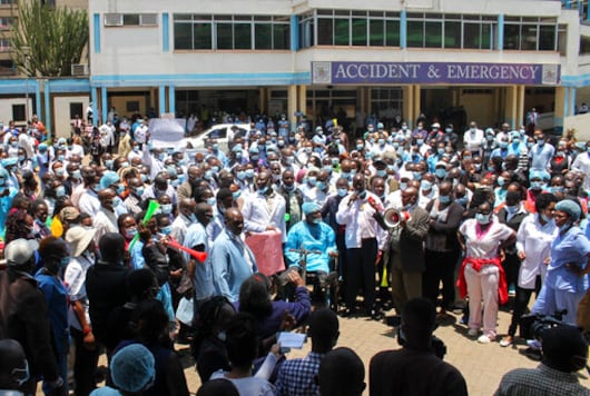 Medical workers strike outside the Accident and Emergency ward at Kenya's largest referral hospital Kenyatta National Hospital in Nairobi, Kenya Monday, Sept. 28, 2020. A witness says a man has died outside an emergency ward of Kenya's largest referral hospital after he was not treated for hours because the staff are on strike over pay raises that were approved in 2012 but according to medical workers not received. (AP Photo)