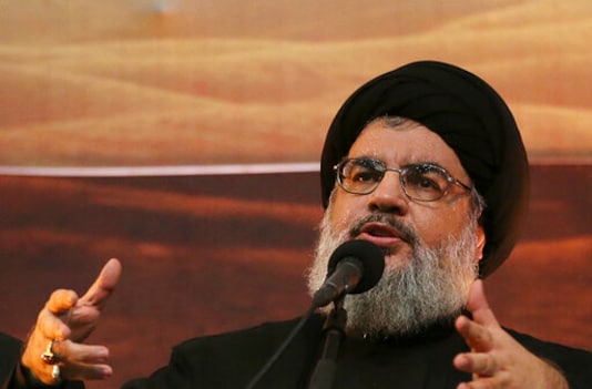 FILE - In this Nov. 3, 2014 file photo, Hezbollah leader Hassan Nasrallah addresses supporters in the southern suburb of Beirut, Lebanon. The Hezbollah leader said Tuesday, Sept. 29, 2020 they still welcome the French initiative to help Lebanon out of its crisis, but said Paris has to change its approach in dealing with local factions and not blame everyone for the failure of forming a new Cabinet. (AP Photo/Hussein Malla, File)