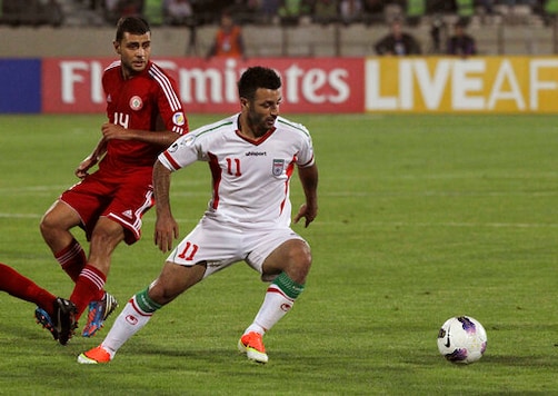 FILE - This Tuesday, June 11, 2013 file photo, Iran's Gholam Reza Rezaei, foreground, plays the ball, as he is followed by Mohamad Atwi, of Lebanon, in their Asian qualifiers soccer match for 2014 World Cup, at the Azadi (Freedom) stadium in Tehran, Iran. Atwi died Friday, Sept. 18, 2020, nearly a month after he was hit by a stray bullet in his head in Beirut, state-run National news agency reported. Atwi had been in intensive care unit since a stray bullet got stuck in his head on Aug. 21. (AP Photo/Vahid Salemi, File) FILE - This Tuesday, June 11, 2013 file photo, Iran's Gholam Reza Rezaei, foreground, plays the ball, as he is followed by Mohamad Atwi, of Lebanon, in their Asian qualifiers soccer match for 2014 World Cup, at the Azadi (Freedom) stadium in Tehran, Iran. Atwi died Friday, Sept. 18, 2020, nearly a month after he was hit by a stray bullet in his head in Beirut, state-run National news agency reported. Atwi had been in intensive care unit since a stray bullet got stuck in his head on Aug. 21. (AP Photo/Vahid Salemi, File)