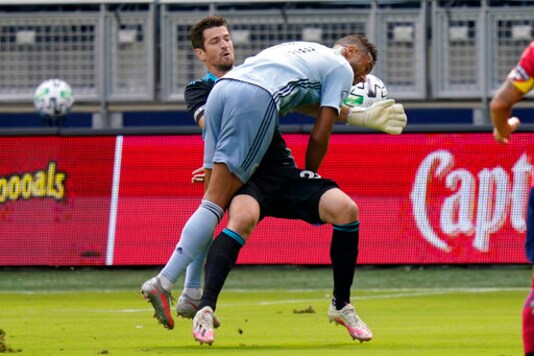 Sporting Kansas City forward Khiry Shelton (11) collides with FC Dallas goalkeeper Jimmy Maurer during the first half of an MLS soccer match in Kansas City, Kan., Saturday, Sept. 19, 2020. (AP Photo/Orlin Wagner)