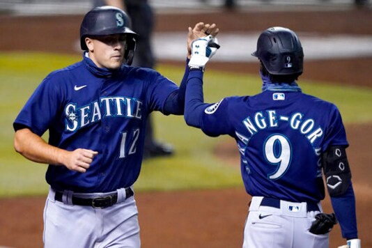 Seattle Mariners' Evan White (12) high fives Dee Strange-Gordon (9) after scoring on a base hit by Jose Marmolejos during the seventh inning of a baseball game against the Arizona Diamondbacks, Friday, Sept. 11, 2020, in Phoenix. AP Photo/Matt York)