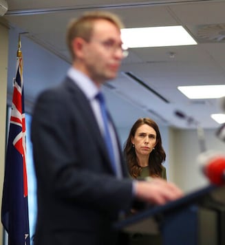 New Zealand Prime Minister Jacinda Ardern watches as Director General of Health Dr Ashley Bloomfield addresses a press conference on COVID-19 in Auckland, New Zealand, Monday, Sept. 21, 2020. All remaining virus restrictions will be lifted across much of New Zealand from late Monday, Sept. 21 with the exception of the largest city, Auckland, which will continue to have some restrictions for at least another 16 days. (Greg Bowker/NZ Herald via AP)