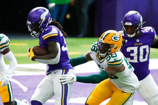 Minnesota Vikings running back Dalvin Cook scores on a 1-yard touchdown run ahead of Green Bay Packers outside linebacker Christian Kirksey (58) during the first half of an NFL football game, Sunday, Sept. 13, 2020, in Minneapolis. (AP Photo/Bruce Kluckhohn)