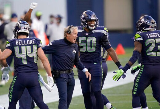 Seattle Seahawks head coach Pete Carroll celebrates with outside linebacker K.J. Wright (50) after wide receiver DK Metcalf scored a touchdown against the New England Patriots during the first half of an NFL football game, Sunday, Sept. 20, 2020, in Seattle. (AP Photo/Elaine Thompson)