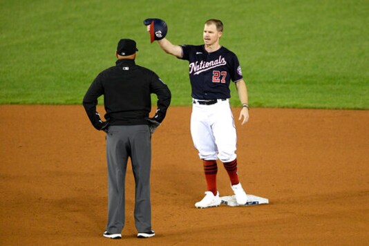 Washington Nationals' Brock Holt stands at second as he talks with second base umpire Vic Carapazza during a pitching change in the seventh inning of a baseball game against the Philadelphia Phillies, Monday, Sept. 21, 2020, in Washington. (AP Photo/Nick Wass)