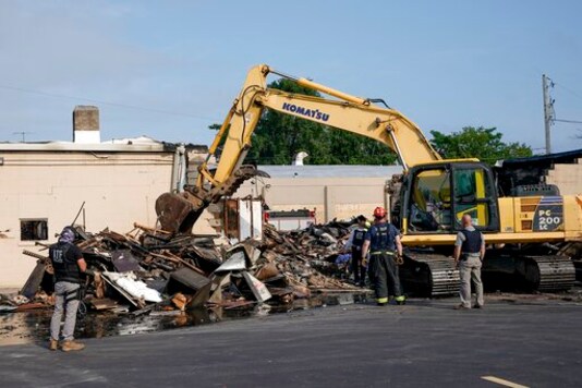 ATF agents look over the damage at an office supply company that was burned during a protest Tuesday, Aug. 25, 2020, in Kenosha, Wis. (AP Photo/Morry Gash)