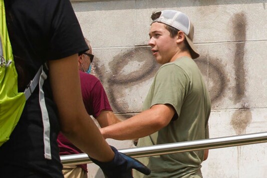 Kyle Rittenhouse helps clean the exterior of Reuther Central High School in Kenosha, Wis., on Tuesday, Aug. 25, 2020. Rittenhouse, 17, was arrested Wednesday, Aug. 26, after two people were shot to death during protests in Kenosha over the police shooting of Jacob Blake. (Pat Nabong/Chicago Sun-Times via AP)