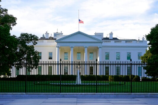 FILE - In this Saturday, Sept. 19, 2020, file photo, an American flag flies at half-staff over the White House in Washington. A woman suspected of sending an envelope containing the poison ricin, which was addressed to White House, has been arrested at the New York-Canada border. (AP Photo/Patrick Semansky, File)