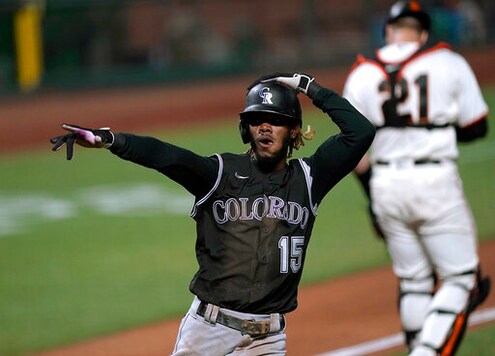 Colorado Rockies' Raimel Tapia (15) points to a teammate after scoring on a single by Trevor Story against the San Francisco Giants during the third inning of a baseball game Wednesday, Sept. 23, 2020, in San Francisco. (AP Photo/Tony Avelar)