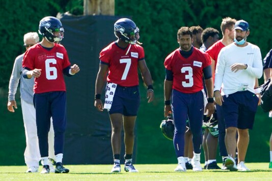 Seattle Seahawks quarterbacks Russell Wilson (3), Geno Smith (7) and Anthony Gordon (6) walk with offensive coordinator Brian Schottenheimer, right, and head coach Pete Carroll, left, following the last day of NFL football training camp, Thursday, Sept. 3, 2020, in Renton, Wash. (AP Photo/Ted S. Warren)
