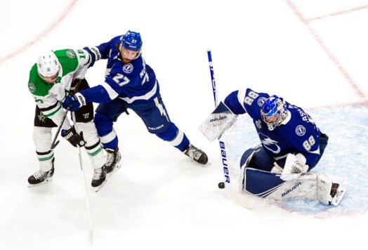 Dallas Stars' Joe Pavelski (16) and Tampa Bay Lightning's Ryan McDonagh (27) battle as Lightning goalie Andrei Vasilevskiy (88) makes a save during first-period NHL Stanley Cup finals hockey action in Edmonton, Alberta, Monday, Sept. 21, 2020. (Jason Franson/The Canadian Press via AP)