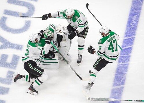 Dallas Stars goalie Anton Khudobin (35), Mattias Janmark (13), Alexander Radulov (47) and Jason Dickinson (18) celebrate their win over the Vegas Golden Knights during overtime NHL Western Conference final playoff game action in Edmonton, Alberta, Monday, Sept. 14, 2020. (Jason Franson/The Canadian Press via AP)