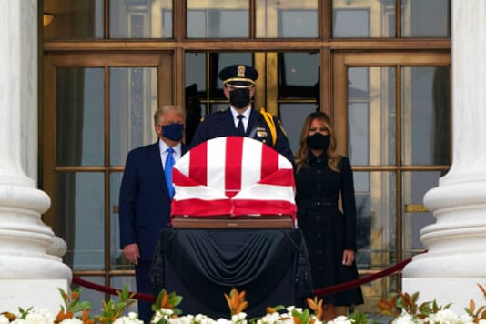 President Donald Trump turns to his left as protesters yell from a block away while he and first lady Melania Trump pay respects as Justice Ruth Bader Ginsburg lies in repose at the Supreme Court building on Thursday, Sept. 24, 2020, in Washington. Ginsburg, 87, died of cancer on Sept. 18. (AP Photo/J. Scott Applewhite)