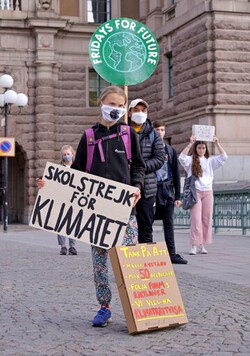 Swedish climate activist Greta Thunberg, center, holding a sign reading Swedish climate activist Greta Thunberg, center, holding a sign reading