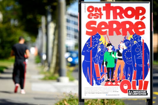 FILE - In this Sept. 8, 2020 file photo, a poster of the Swiss People's Party (SVP) for a moderate immigration initiative reading 'we're too tight!' is displayed in a street in Lausanne, Switzerland. The Swiss vote this weekend on whether to limit the number of European Union citizens who can live and work in Switzerland, a measure championed by a populist party that wants to make sure the Swiss get preferential access to jobs, social protections and benefits in the rich Alpine country. (Laurent Gillieron/Keystone via AP, file) FILE - In this Sept. 8, 2020 file photo, a poster of the Swiss People's Party (SVP) for a moderate immigration initiative reading 'we're too tight!' is displayed in a street in Lausanne, Switzerland. The Swiss vote this weekend on whether to limit the number of European Union citizens who can live and work in Switzerland, a measure championed by a populist party that wants to make sure the Swiss get preferential access to jobs, social protections and benefits in the rich Alpine country. (Laurent Gillieron/Keystone via AP, file)