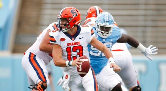 Syracuse quarterback Tommy DeVito (13) scrambles to avoid North Carolina defender Jahlil Taylor (52) in first half of an NCAA college football game, Saturday, Sept. 12, 2020 in Chapel Hill, N.C. (Robert Willett/The News & Observer via AP)