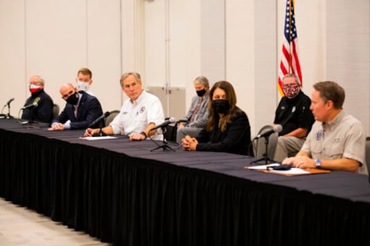Texas Governor Greg Abbott and other state officials listen to Texas Commission on Environmental Quality executive director Toby Baker talk about steps to be taken so water is safe again for the community of Lake Jackson, Texas on Tuesday, Sept. 29, 2020. A Houston-area official says it will take 60 days to ensure a city drinking water system is purged of a deadly, microscopic parasite that led to warnings over the weekend not to drink tap water. Lake Jackson City Manager Modesto Mundo said Monday that three of 11 samples of the city's water indicated preliminary positive results for the naegleria fowleri microbe. (Marie D. De Jess/Houston Chronicle via AP)