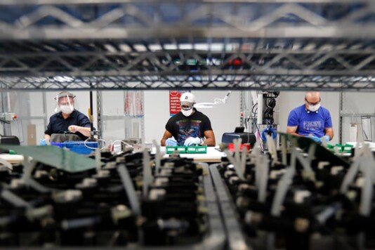 FILE - In this May 13, 2020, file photo, Ford Motor Co., line workers put together ventilators that the automaker is assembling at the Ford Rawsonville plant in Ypsilanti Township, Mich. American industry rebounded last month as factories began to reopen for the first time since being shut down by the coronavirus in Aprll. The Federal Reserve said Tuesday, June 16, 2020, that industrial production  including output at factories, mines and utilities  rose 1.4% in May after plummeting a record 12.4% in April and 4.6% in March. (AP Photo/Carlos Osorio, File)