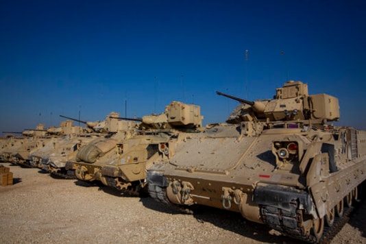 FILE - In this Nov. 11, 2019, file photo, Bradley fighting vehicles are parked at a U.S. military base at an undisclosed location in Northeastern Syria, Monday, Nov. 11, 2019. The U.S. has deployed additional troops and armored vehicles into eastern Syria after a number of clashes with Russian forces, including a recent vehicle collision that injured four American service members. (AP Photo/Darko Bandic, File)