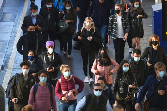 Commuters at Waterloo Station, in London, Thursday, Sept. 24, 2020, after Britain's Prime Minister Boris Johnson announced a range of new restrictions to combat the rise in coronavirus cases in England. (Victoria Jones/PA via AP)