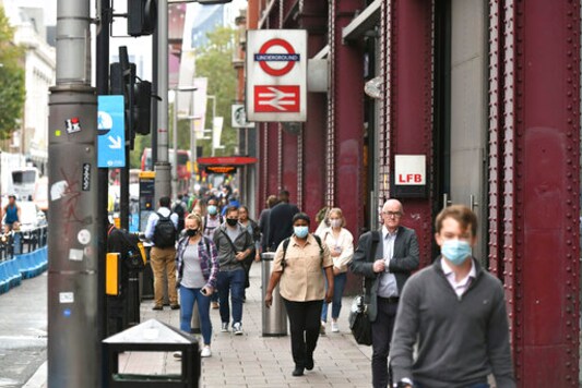 People exit Waterloo station in London, Wednesday, Sept. 23, 2020, after Prime Minister Boris Johnson announced a range of new restrictions to combat the rise in coronavirus cases in England, Wednesday, Sept. 23, 2020. (Dominic Lipinski/PA via AP)