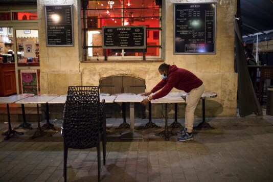 A waiter closes a bar terrace in Marseille, southern France, late Sunday Sept. 27, 2020. As restaurants and bars in Marseille prepared Sunday to shut down for a week as part of scattered new French coronavirus restrictions, Health Minister Olivier Veran insisted that the country plans no fresh lockdowns. (AP Photo/Daniel Cole) A waiter closes a bar terrace in Marseille, southern France, late Sunday Sept. 27, 2020. As restaurants and bars in Marseille prepared Sunday to shut down for a week as part of scattered new French coronavirus restrictions, Health Minister Olivier Veran insisted that the country plans no fresh lockdowns. (AP Photo/Daniel Cole)