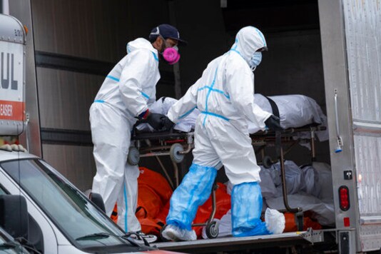 FILE - In this April 29, 2020, file photo, workers move bodies to a refrigerated truck from the Andrew T. Cleckley Funeral Home in the Brooklyn borough of New York. During the deadliest days of the coronavirus outbreak in New York City, the bodies piled up at the funeral home  and the stench that came with it  at an alarming rate. Cleckley says what happened next made him the scapegoat for an unforeseen crisis  hundreds of COVID-19 deaths a day in New York that overwhelmed funeral homes across the city. Authorities swept in and suspended his license in an episode that made headlines in a city already reeling from other horrors of the pandemic. (AP Photo/Craig Ruttle)