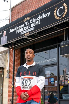 Funeral director Andrew T. Cleckley poses for a portrait at his funeral home, Wednesday, Sept. 16, 2020, in the Flatlands neighborhood of the Brooklyn borough of New York.  When the city was experiencing hundreds of coronavirus deaths a day, passersby reported a stench coming from rental trucks outside the facility in Brooklyn used to store an overflow of bodies. Authorities swept in and suspended his license in an episode that made headlines. Months later, Cleckley is fighting to keep his business.(AP Photo/Mary Altaffer)