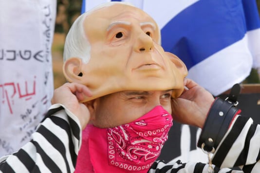 A protester wears a bandana as a face mask as he pulls on a rubber mask representing Israeli Prime Minister Benjamin Netanyahu outside of the Knesset in Jerusalem, Thursday, Sept. 24, 2020, after Israel moved to further tighten its second countrywide lockdown as coronavirus cases continue to soar. Prayers during the ongoing Jewish High Holidays, as well as political demonstrations, would be limited to open spaces and no more than 20 people, and participants would have to remain within the restricted distance from home. (AP Photo/Maya Alleruzzo) A protester wears a bandana as a face mask as he pulls on a rubber mask representing Israeli Prime Minister Benjamin Netanyahu outside of the Knesset in Jerusalem, Thursday, Sept. 24, 2020, after Israel moved to further tighten its second countrywide lockdown as coronavirus cases continue to soar. Prayers during the ongoing Jewish High Holidays, as well as political demonstrations, would be limited to open spaces and no more than 20 people, and participants would have to remain within the restricted distance from home. (AP Photo/Maya Alleruzzo)