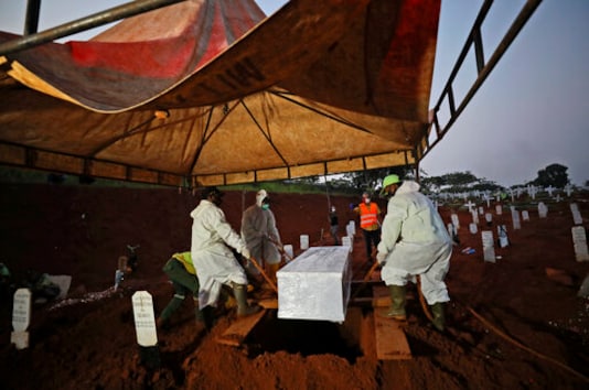 Workers lower a coffin containing the body of a suspected COVID-19 victim into a grave during a burial at the special section of Pondok Ranggon cemetery which was opened to accommodate the surge in deaths during coronavirus outbreak in Jakarta, Indonesia, Thursday, Sept. 24, 2020. (AP Photo/Dita Alangkara) Workers lower a coffin containing the body of a suspected COVID-19 victim into a grave during a burial at the special section of Pondok Ranggon cemetery which was opened to accommodate the surge in deaths during coronavirus outbreak in Jakarta, Indonesia, Thursday, Sept. 24, 2020. (AP Photo/Dita Alangkara)