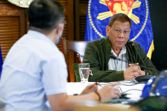 In this photo provided by the Malacanang Presidential Photographers Division, Philippine President Rodrigo Duterte, right, listens as he meets members of the Inter-Agency Task Force on the Emerging Infectious Diseases in Davao province, southern on Monday Sept. 21, 2020. Duterte says he has extended a state of calamity in the entire Philippines by a year to allow the government to draw emergency funds faster to fight the COVID-19 pandemic and harness the police and military to maintain law and order. (Albert Alcain/Malacanang Presidential Photographers Division via AP)