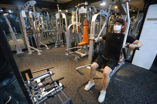 A man wearing a face mask to help protect against the spread of the coronavirus exercises at Chungwoon Sporex in Seoul, South Korea, Tuesday, Sept. 15, 2020. South Korea's daily tally of new coronavirus infections has stayed in the low 100s for a third consecutive day, maintaining a downward trajectory. (AP Photo/Ahn Young-joon)
