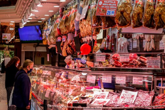 People wearing face masks to prevent the spread of coronavirus buy charcuterie products in downtown Madrid, Spain, Friday, Sept. 18, 2020. With more than 11,000 new daily coronavirus cases, the attention in Spain is focusing on its capital, where officials are mulling localized lockdowns and other measures to bring down the curve of contagion. (AP Photo/Manu Fernandez)
