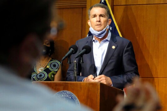 FILE - In this Sept. 1, 2020 file photo, Virginia Gov. Ralph Northam listens to a reporter's question during a press briefing inside the Patrick Henry Building in Richmond, Va.  Northam and his wife have both tested positive for the coronoavirus. The governors office said in a statement Friday, Sept. 25,  that Northam no symptoms while those of Pam Northam are mild.(Bob Brown/Richmond Times-Dispatch via AP)