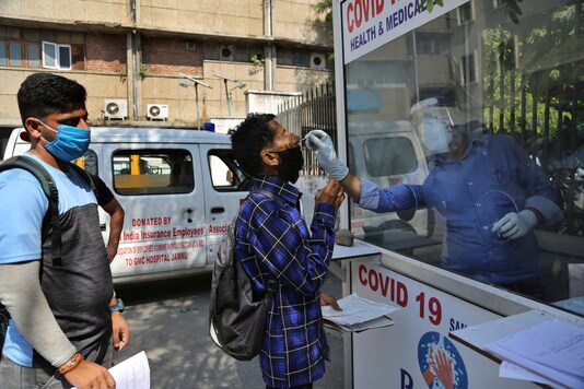A health worker collects a man's swab sample to test for Covid-19 at a government hospital in Jammu, on October 1, 2020. (AP Photo/Channi Anand)