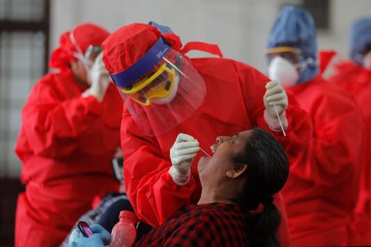 Sri Lankan health officials take swab samples from employees of the Colombo municipal council to test for COVID-19 in Colombo, Sri Lanka, Wednesday, Oct. 7, 2020. (AP Photo/Eranga Jayawardena, File)
