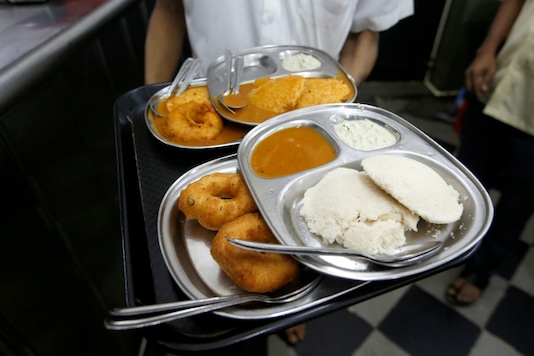 A waiter holds a tray containing plates with medu vada and idli sambar at a South Indian restaurant in Mumbai. Reuters/Francis Mascarenhas
