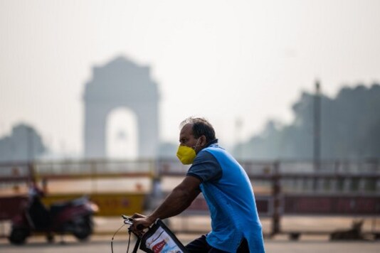 A cyclist rides past India Gate amid smoggy condition in New Delhi. (AFP)