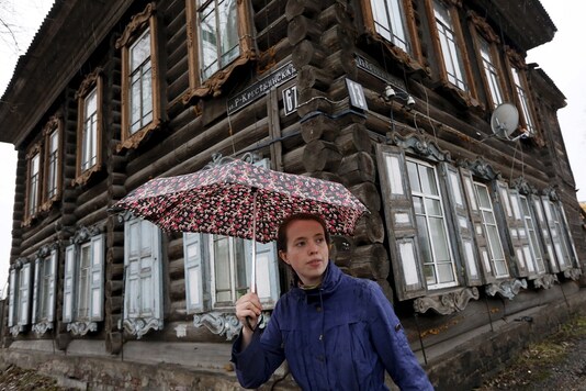 A woman walks past a wooden residential house in a town in Siberia. (For representation/REUTERS) A woman walks past a wooden residential house in a town in Siberia. (For representation/REUTERS)