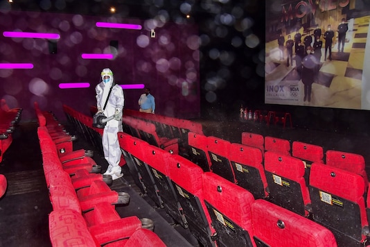 Image for representation. A worker sanitises a cinema hall ahead of its re-opening.