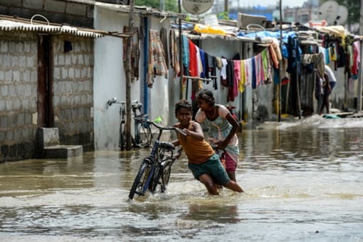 Children push a bicycle on a flooded street following heavy rains in Hyderabad recently. (File photo/PTI)